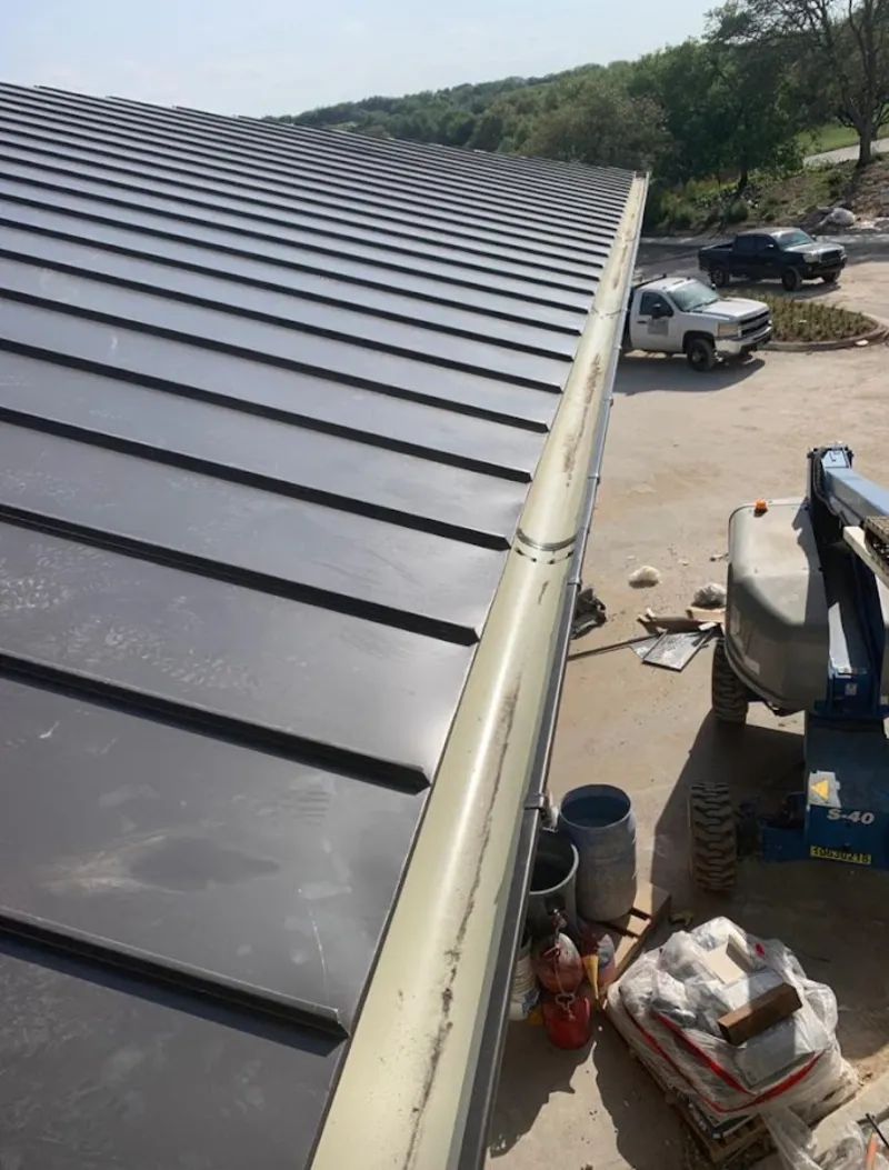 Standing seam panel and gutter detail on a metal roofing jobsite in Marshfield